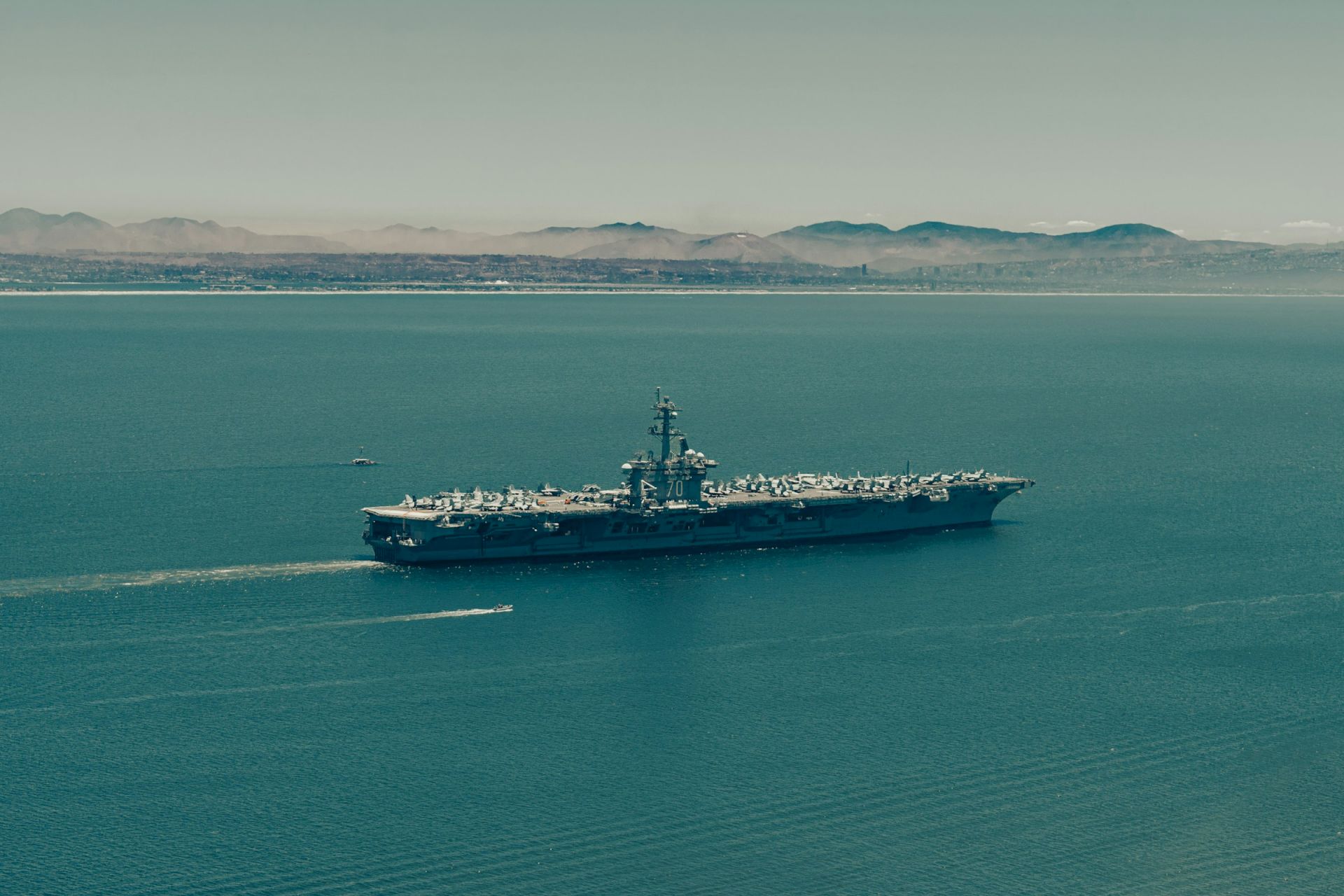 Navy aircraft carrier sailing through the blue waters off San Diego